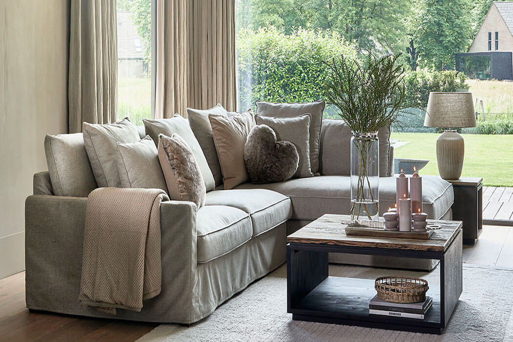 Rivièra Maison Ecksofa mit herbstlichen Kissen in einem Wohnzimmer