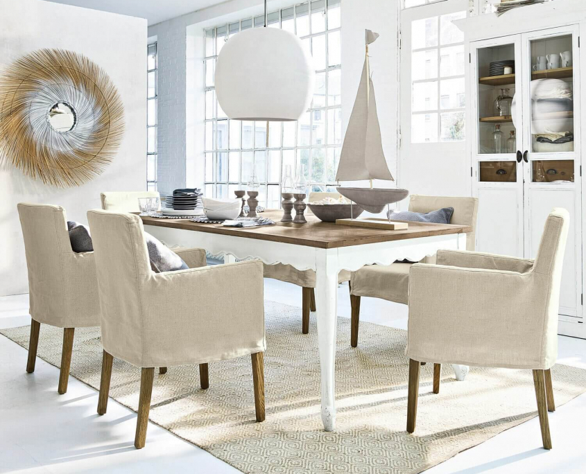 Ein Esszimmer in der Farbe Beige mit Hussenstühlen und Esstisch