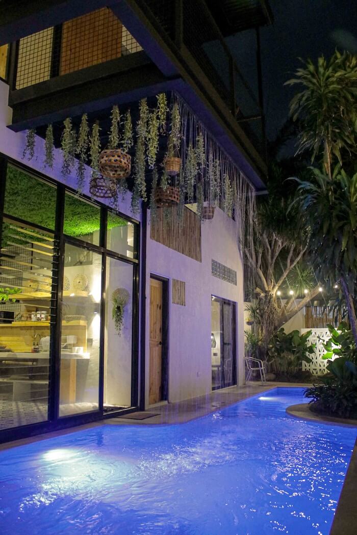 Beleuchteter Pool mit Randbepflanzung am Haus