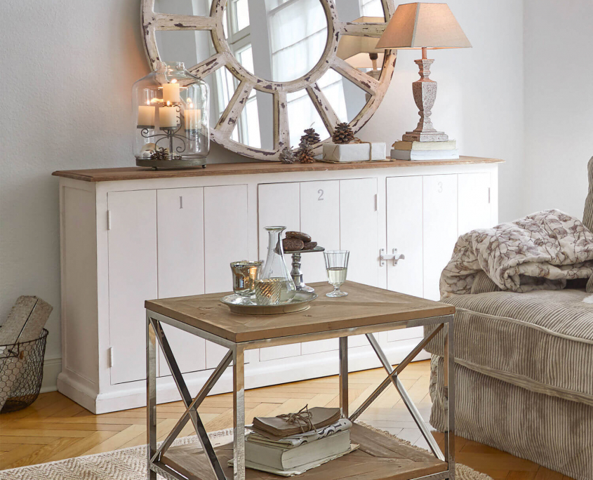 Weiße Landhausmöbel mit dekoriertem Sideboard in einem Wohnzimmer
