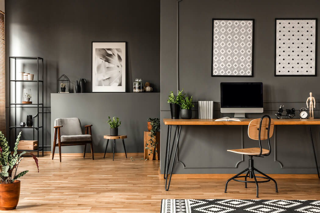 Moderne Einrichtung in Grau mit Schreibtisch und Wohnbereich im Hintergrund sichtbar