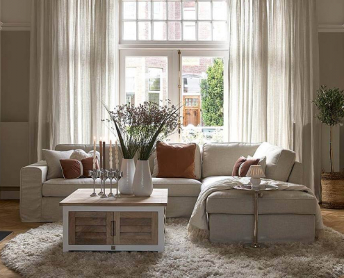 Riviera Maison Sofa mit Pacifica Schränken in einem hellem Wohnzimmer mit flauschigem Teppich